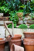 Terracotta pots with Soleirolia soleirolii, tool head and containers. Lucille Lewins, small office court yard garden in Chiltern street studios, London. Designed by Adam Woolcott and Jonathan Smith