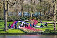 Visitors gather for pictures and selfies around one of the massed bulb displays at Keukenhof in Holland. To the right a father prevents his stroller from running away by using his foot as a brake.