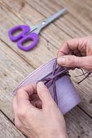 Tie the coloured raffia around the top of the terracotta pot into a bow