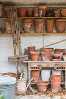 Garden storage buildings with old flower pots on shelves.
