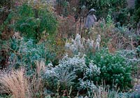 Mixed deep border with ornamental stone statue in the frost. 