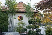 Circular view through garden building, Phyllostachys nigra, Pinus sylvestris and Acer palmatum 'Nicholsonii' in early morning sun, A Japanese Reflection, RHS Malvern Spring Festival 2016