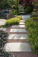 Stepping stones set in gravel, lined with Hakonechloa macra and Ophiopogon planiscapus 'Nigra' - A Japanese Reflection, RHS Malvern Spring Festival 2016
