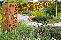 Decorative panels by Natasha Webb, surrounded by Tiarella cordifolia, Taxus baccata, Cirsium rivulare 'Atropurpurea',  The Sunken Retreat, RHS Malvern Spring Festival 2016