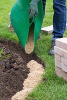 Fill the excavated trench with sand leaving a 2 inch gap from ground level