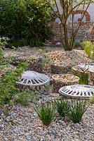 Gravel planting with Centaurea montana 'Crystal Cloud' and flint-filled Coccolith gabions in 'The Brewin Dolphin Garden - Forever Freefolk . The RHS Chelsea Fower Show 2016 - Designer: Rosy Hardy - Sponsor: Brewin Dolphin - SILVER GILT