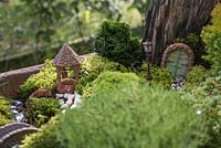 Miniature Wheelbarrow Garden. A miniature garden inside a wheelbarrow made with Moss, Conifers, decorative stones, seashells, animal and structural figurines