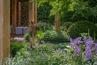 John O'Connor's bronze sculpture 'Joy' in front of an oak pavilion, surrounded by planting of  Geranium 'Johnson's Blue', Phalaris arundinacea 'Feesey', Hesperis matronalis, Acer palmatum 'Seiryu' and Taxus baccata domes in The Morgan Stanley Garden For Great Ormond Street Hospital. The RHS Chelsea Flower Show 2016 - Designer: Chris Beardshaw - Sponsor: Morgan Stanley - GOLD