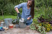 Using metal cutters to create a hole in the bottom of a galvanised bucket