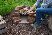 Using paper and kindling to create a fire within the barbecue