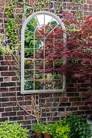 A window shaped mirror reflecting light into a courtyard.