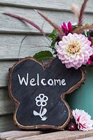 Oak tree slice painted and decorated to display 'Welcome' with Dahlia arrangement