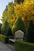 Wooden garden bench in formal country garden, November 