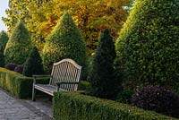 Wooden garden bench in formal country garden 