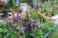 New Horizons City Garden. Coloured Fused glass panels in colourful border of orange,red and blues. Designers: Beautiful Borders, Sponsors: Beautiful borders Garden Design. RHS Hampton Court Palace Flower Show 2016