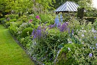 Summer border includes Salvia x sylvestris 'Dear Anja', Delphinium Belladonna-Hybride 'Piccolo', Rosa 'Rhapsody In Blue', Geranium riversleaianum 'Russel Prichard'. Sarina Meijer garden