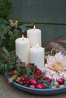 Autumnal display with lit candles, Dahlia 'Cafe au Lait', Crab Apples and Hawthorn berries