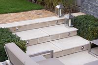 White stone steps with built in lighting feature, leading down to the sunken seating area