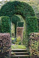 Hedges of yew and hornbeam frame a path through the garden.