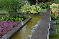 Detail pond with wall fountain and border with Thymus.