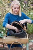 Step-by-Step planting autumn baskets: a round basket is lined with a permeable garden fabric.