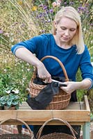 Step-by-Step planting autumn baskets: the permeable fabric is trimmed level with the top edge of the basket.