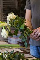 Constructing a Winter bouquet with Rosa 'Avalanche', Viburnum tinus and Hippeastrum 'Christmas Gift'