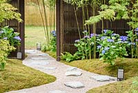 Path leading between moss lawn with Acer palmatum, Hydrangea macrophylla 'Blaumeise' and Phyllostachys - Japanese Summer Garden, RHS Hampton Court Palace Flower Show 2016 - Design: Saori Imoto