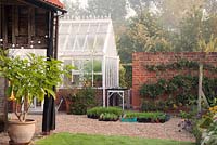 Young plants in containers alongside greenhouse. Ulting Wick, Essex