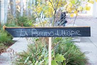 Signboard with crayons written text La pseudo Utopie.