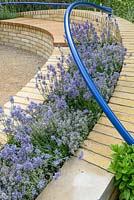 Blue curving handrails above brickbenches with Lavandula 'Hidcote'. The Abbeyfield Society: a Breath of Fresh Air, RHS Hampton Court Palace Flower Show 2016. Design: Rae Wilkinson