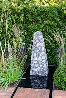 Flint sculpture at the end of the water, Streetscape's Summer in Sussex Garden, RHS Hampton Court Palace Flower Show 2016. Designed by Will Williams