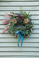 A festive Christmas wreath made with Eucalyptus, Pine cones, Pine foliage and Pheasant feathers