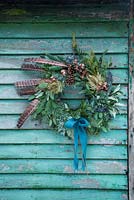 A festive Christmas wreath made with Eucalyptus, Pine cones, Pine foliage and Pheasant feathers