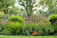 Summer border of Persicaria amplexicaulis 'Border Beauty', Phlox, Crocosmia 'Limpopo', Hellenium, Hemerocallis, roses. Anneke Meinhardt garden
