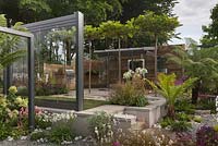 An outdoor kitchen with dining area and framed glass panels - Through The Looking Glass at RHS Tatton Park Flower Show 2016