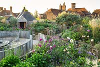 View across pub garden with seating area with fire burner and late summer border, Jo Thompson garden Design, Ticehurst, East Sussex