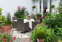 A circular stone terrace with dining table is positioned in a sheltered spot outside the sitting room, and edged in lavender, roses, lythrum, centranthus and hardy geranium.