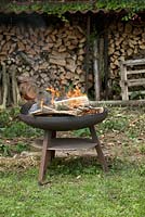 Metal fire pit in front of wood store