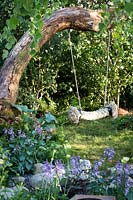 Hampton Court Flower Show, 2017. The 'Zoflora and Caudwell' Children's Wild Garden. Children's rope swing in shady woodland garden