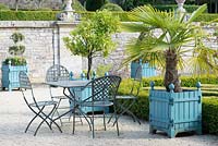 Seating and Versailles planters on gravelled area at Chateau Brecy, France