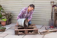 Woman filling pallet with compost