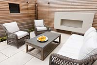 Seating area on patio surrounded by cedar panelling 
