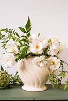 Flower arrangement with white roses, jasmine and ferns in cream china jug