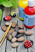 Garden craft making painted Bumble bees and Ladybirds with stones.  Materials needed - coloured paint, paintbrushes and stones