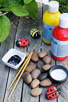 Garden craft making painted Bumble bees and Ladybirds with stones. Materials needed -  red, yellow, black and white coloured paint, paintbrushes and stones