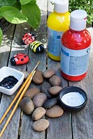 Garden craft making painted Bumble bees and Ladybirds with stones. Materials needed -  red, yellow, black and white coloured paint, paintbrushes and stones