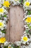 Border of decorative spring flowers on wooden board