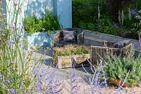 Paved seating area with Linaria purpurea 'Canon Went' in a shallow container, border with Stipa gigantea and Verbena bonariensis - Viking Cruises World of Discovery Garden, RHS Hampton Court Palace Flower Show 2017 -Designer: Paul Hervey-Brookes