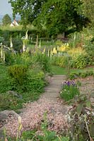 The gravel path leads past the summer Lupins border to the crochet lawn.